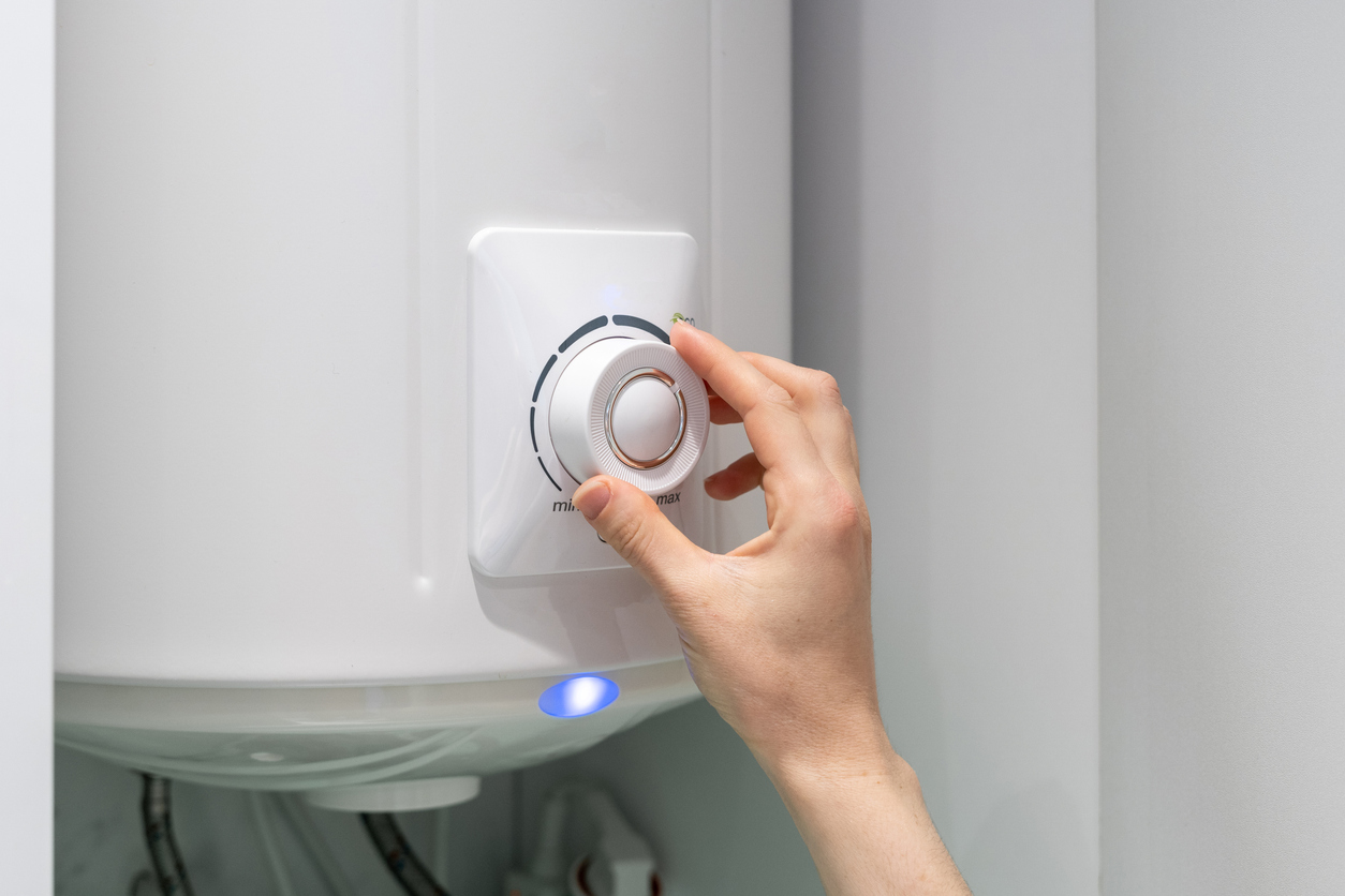 Hand changing the temperature on a boiler